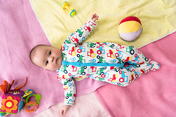 Image showing top view of newborn baby boy lying on colorful blankets