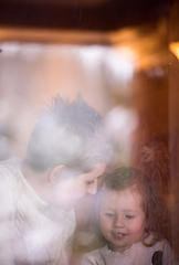 Image showing young mother and little cute daughter playing near the window