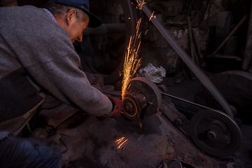 Image showing the blacksmith polishing metal products