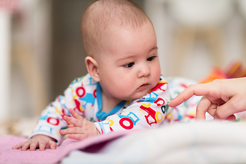 Image showing newborn baby boy playing on the floor