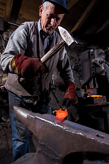 Image showing blacksmith manually forging the molten metal