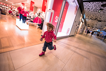 Image showing little girl running through shopping mall