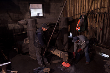 Image showing blacksmith workers using mechanical hammer at workshop