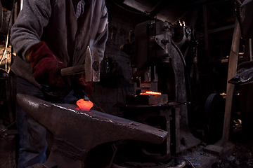 Image showing blacksmith manually forging the molten metal