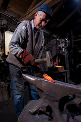 Image showing blacksmith manually forging the molten metal