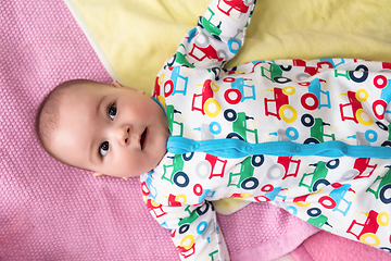 Image showing top view of newborn baby boy lying on colorful blankets