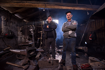 Image showing portrait of two generations confident blacksmith