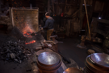 Image showing young traditional Blacksmith working with open fire