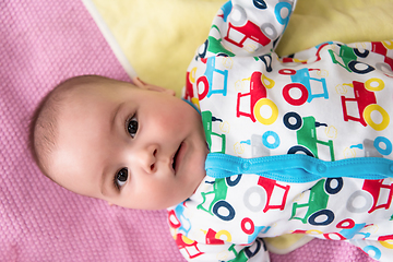 Image showing top view of newborn baby boy lying on colorful blankets