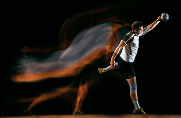 Image showing Young handball player against dark studio background in mixed light