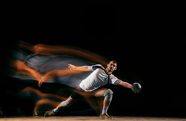 Image showing Young handball player against dark studio background in mixed light