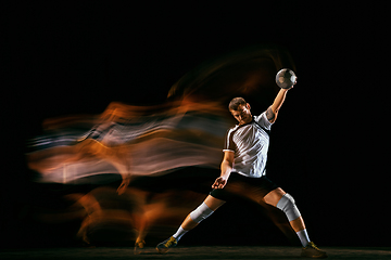 Image showing Young handball player against dark studio background in mixed light