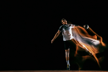 Image showing Young handball player against dark studio background in mixed light