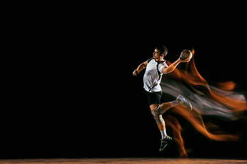 Image showing Young handball player against dark studio background in mixed light