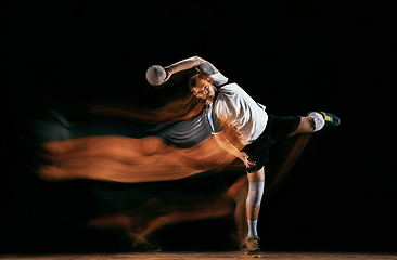 Image showing Young handball player against dark studio background in mixed light