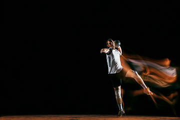 Image showing Young handball player against dark studio background in mixed light