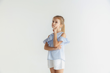 Image showing Little smiling girl posing in casual clothes on white studio background