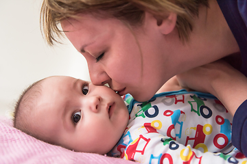 Image showing young mother kissing her cute little baby