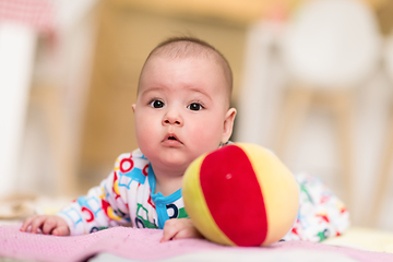 Image showing newborn baby boy playing on the floor