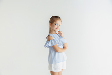 Image showing Little smiling girl posing in casual clothes on white studio background