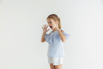 Image showing Little smiling girl posing in casual clothes on white studio background