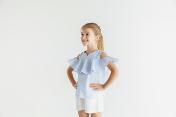 Image showing Little smiling girl posing in casual clothes on white studio background