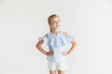 Image showing Little smiling girl posing in casual clothes on white studio background