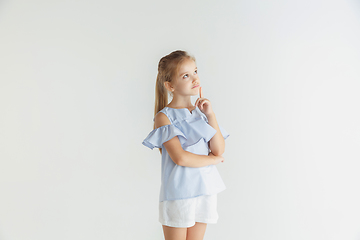 Image showing Little smiling girl posing in casual clothes on white studio background