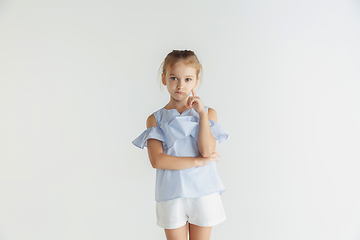 Image showing Little smiling girl posing in casual clothes on white studio background