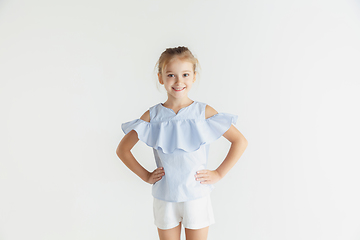 Image showing Little smiling girl posing in casual clothes on white studio background