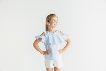 Image showing Little smiling girl posing in casual clothes on white studio background