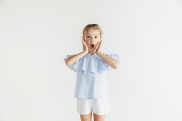 Image showing Little smiling girl posing in casual clothes on white studio background