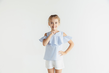 Image showing Little smiling girl posing in casual clothes on white studio background