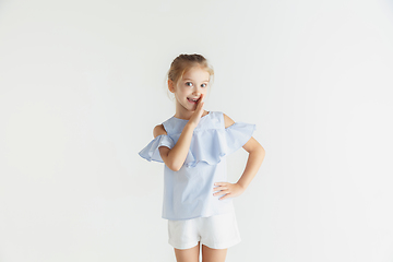 Image showing Little smiling girl posing in casual clothes on white studio background