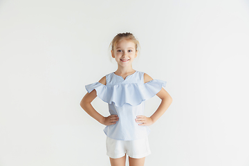 Image showing Little smiling girl posing in casual clothes on white studio background