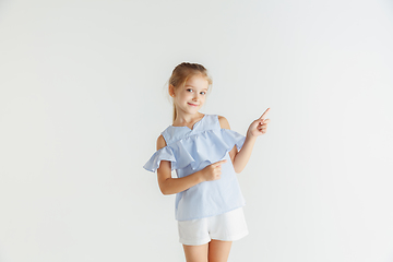 Image showing Little smiling girl posing in casual clothes on white studio background