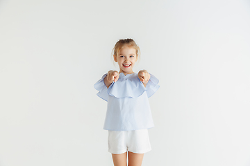 Image showing Little smiling girl posing in casual clothes on white studio background