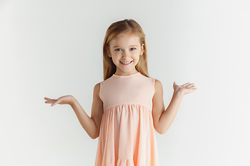 Image showing Little smiling girl posing in dress on white studio background