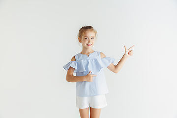 Image showing Little smiling girl posing in casual clothes on white studio background