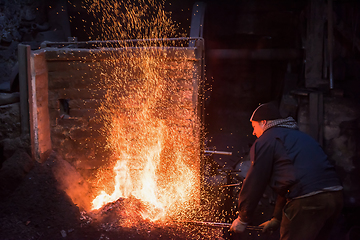 Image showing young traditional Blacksmith working with open fire