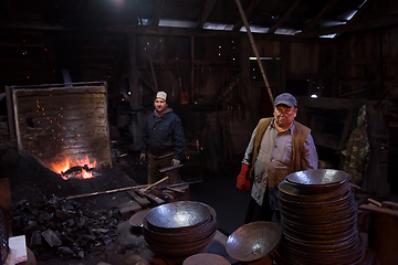 Image showing portrait of two generations traditional blacksmith