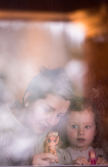 Image showing young mother and little cute daughter playing near the window