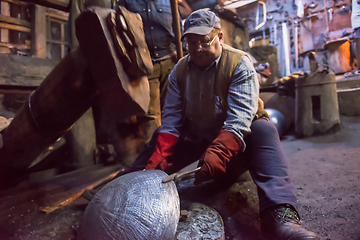 Image showing blacksmith workers using mechanical hammer at workshop