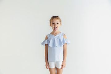 Image showing Little smiling girl posing in casual clothes on white studio background