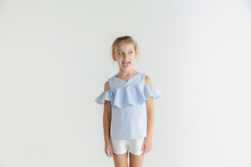 Image showing Little smiling girl posing in casual clothes on white studio background