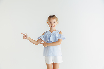 Image showing Little smiling girl posing in casual clothes on white studio background