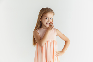 Image showing Little smiling girl posing in dress on white studio background