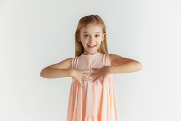 Image showing Little smiling girl posing in dress on white studio background