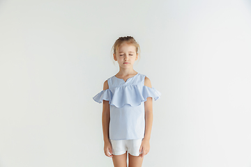 Image showing Little smiling girl posing in casual clothes on white studio background