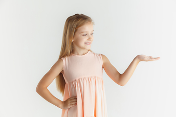 Image showing Little smiling girl posing in dress on white studio background